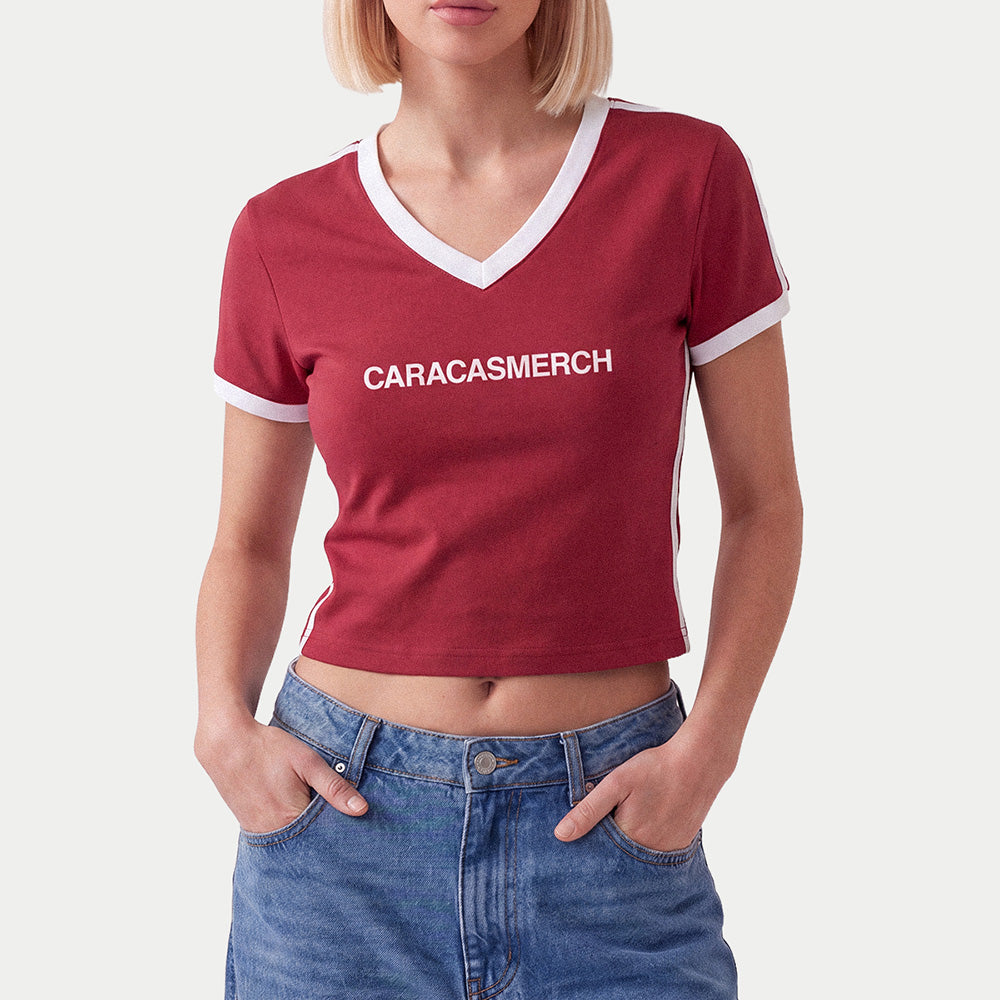 Woman wearing the burgundy Caracasmerch soccer crop tee with blue jeans